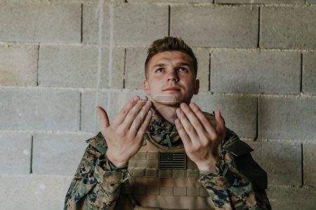 Téléchargez les photos : Un soldat musulman des forces spéciales prie Dieu en levant la main et commence une prière. - en image libre de droit