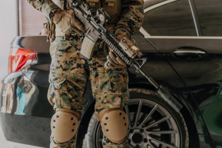 Foto de American marine corps special operations soldier preparing tactical and communication gear for action battle closeup. - Imagen libre de derechos