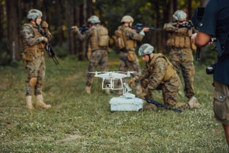 Foto de El escuadrón de soldados de guerra moderna está usando aviones no tripulados para explorar y vigilar durante la operación militar en el bosque - Imagen libre de derechos