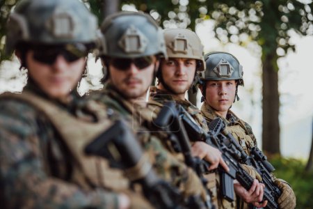 Foto de Combatientes soldados de pie junto con armas de fuego. Retrato de grupo de miembros de élite del ejército estadounidense, militares privados, escuadrón antiterrorista. - Imagen libre de derechos