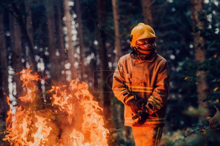 Photo for Firefighter at job. Firefighter in dangerous forest areas surrounded by strong fire. Concept of the work of the fire service. H - Royalty Free Image