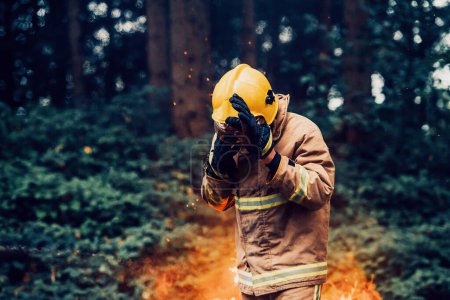 Photo pour Pompier au travail. Pompier dans des zones forestières dangereuses entourées de feux violents. Concept du travail du service d'incendie. H - image libre de droit