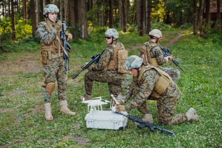 Photo for Modern Warfare Soldiers Squad are Using Drone for Scouting and Surveillance During Military Operation in the Forest. - Royalty Free Image