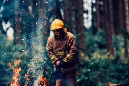 Téléchargez les photos : Pompier au travail. Pompier dans des zones forestières dangereuses entourées de feux violents. Concept du travail du service d'incendie. H - en image libre de droit