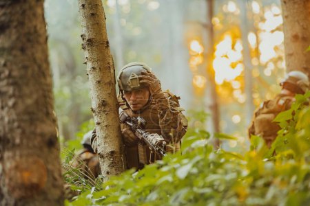 Téléchargez les photos : Soldat de guerre moderne en service dans des zones forestières denses et dangereuses. Opérations de sauvetage militaire dangereuses. - en image libre de droit