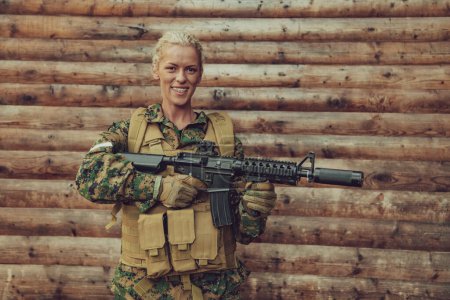 Foto de Mujer soldado listo para la batalla usando equipo militar protector y arma. - Imagen libre de derechos
