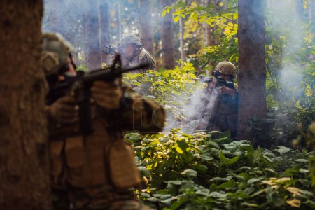 Foto de Un grupo de soldados de guerra modernos está librando una guerra en zonas forestales remotas y peligrosas. Un grupo de soldados está luchando en la línea enemiga con armas modernas. El concepto de guerra y militar - Imagen libre de derechos