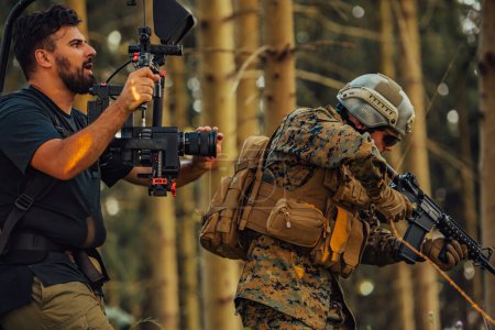 Photo for Videographer with Professional Movie Video Camera Gimbal Stabilizing Equipment Taking Action Shoot of Soldiers in Action in Forest. - Royalty Free Image