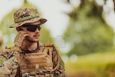 Téléchargez les photos : Corps de marine américain soldat des opérations spéciales préparant matériel tactique et de communication pour l'action bataille gros plan. - en image libre de droit