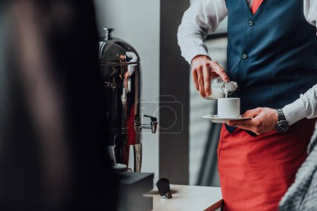 Téléchargez les photos : Le serveur prépare le café pour les clients de l'hôtel. Photo rapprochée du service dans les hôtels modernes. - en image libre de droit