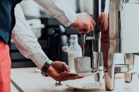 Foto de El camarero preparando café para los huéspedes del hotel. De cerca la foto del servicio en los hoteles modernos. - Imagen libre de derechos