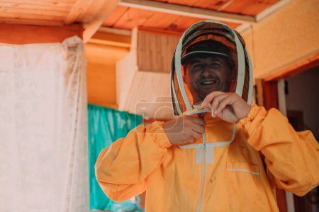 Photo for Beekeeper put on a protective beekeeping suit and preparing to enter the apiary. - Royalty Free Image
