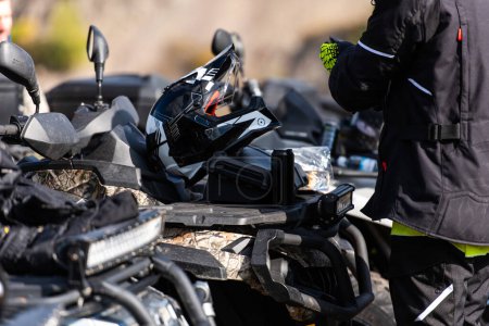 Foto de Un hombre se está preparando para un viaje aventurero en una moto cuádruple. Foto de alta calidad - Imagen libre de derechos