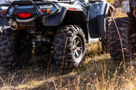 Photo for Close-up tail view of ATV quad bike on dirt country road. Dirty wheel of AWD all-terrain vehicle. Travel and adventure concept - Royalty Free Image