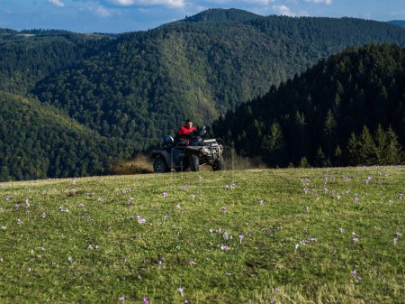 Foto de Un hombre conduciendo una motocicleta quad ATV a través de hermosos paisajes del prado. Foto de alta calidad - Imagen libre de derechos