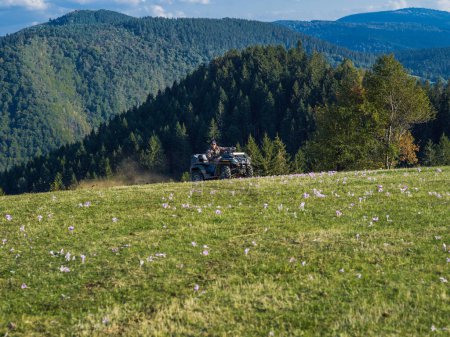 Photo for A man driving a quad ATV motorcycle through beautiful meadow landscapes. High quality photo - Royalty Free Image
