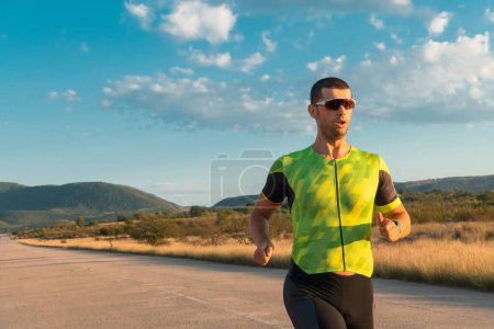 Photo for Triathlete in professional gear running early in the morning, preparing for a marathon, dedication to sport and readiness to take on the challenges of a marathon - Royalty Free Image