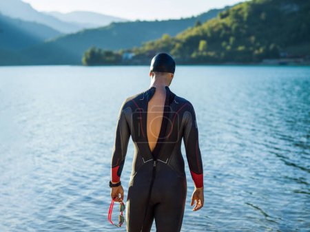 Téléchargez les photos : Un nageur de triathlon se préparant à un entraînement en rivière pour se préparer à un marathon. Photo de haute qualité - en image libre de droit