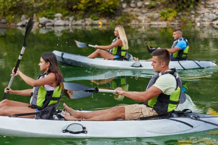 Foto de Un grupo de amigos disfrutando de divertirse y hacer kayak mientras exploran el río tranquilo, el bosque circundante y los grandes cañones naturales del río.. - Imagen libre de derechos