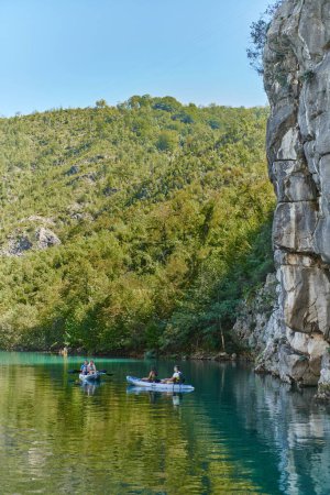 Téléchargez les photos : Un groupe d'amis profitant du plaisir et du kayak tout en explorant la rivière calme, la forêt environnante et les grands canyons naturels de la rivière. - en image libre de droit