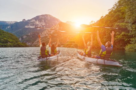 Photo for A group of friends enjoying fun and kayaking exploring the calm river, surrounding forest and large natural river canyons during an idyllic sunset - Royalty Free Image