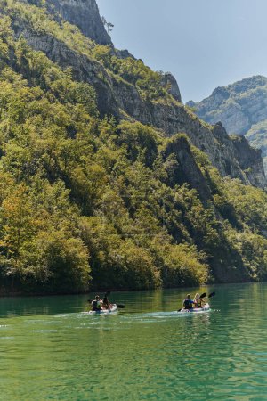 Téléchargez les photos : Un groupe d'amis profitant du plaisir et du kayak tout en explorant la rivière calme, la forêt environnante et les grands canyons naturels de la rivière. - en image libre de droit