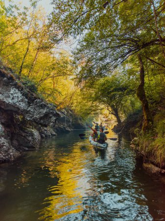 Téléchargez les photos : Un jeune couple profitant d'une balade en kayak idyllique au milieu d'une belle rivière entourée de verdure forestière. - en image libre de droit