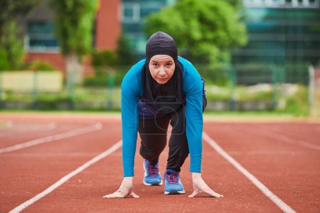 Foto de Mujer musulmana en burka con ropa deportiva musulmana en pose inicial para correr. Foto de alta calidad - Imagen libre de derechos