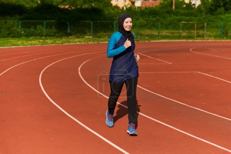 Photo for A muslim woman in a burqa sports muslim clothes running on a marathon course and preparing for upcoming competitions. - Royalty Free Image