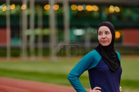 Photo for A Muslim woman with a burqa, an Islamic sportswoman resting after a vigorous training session on the marathon course. A hijab woman is preparing for a marathon competition. - Royalty Free Image