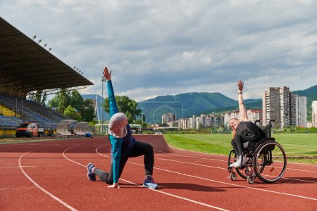 Photo for Two strong and inspiring women, one a Muslim wearing a burka and the other in a wheelchair stretching and preparing their bodies for a marathon race on the track. - Royalty Free Image