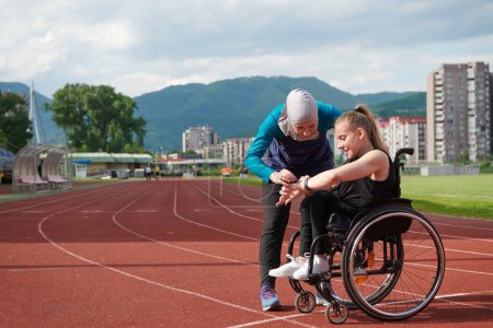Foto de Una mujer con discapacidad en silla de ruedas hablando con un amigo después de entrenar en el curso de maratón. - Imagen libre de derechos