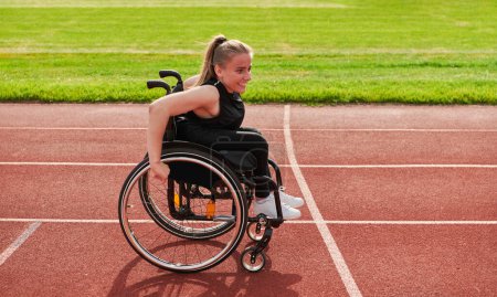 Téléchargez les photos : Une femme handicapée conduisant un fauteuil roulant sur une piste alors qu'elle se prépare pour les Jeux paralympiques. - en image libre de droit