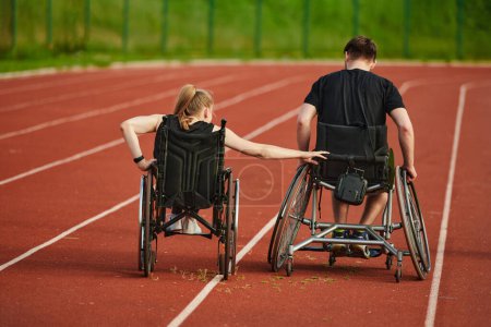 Téléchargez les photos : Un couple de personnes handicapées inspirantes font preuve d'une détermination et d'une force incroyables alors qu'elles s'entraînent ensemble pour les Jeux paralympiques en poussant leur fauteuil roulant sur une piste de marathon. - en image libre de droit