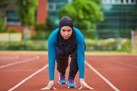 Photo for Muslim woman in burqa in sporty Muslim clothes in starting pose for running. High quality photo - Royalty Free Image