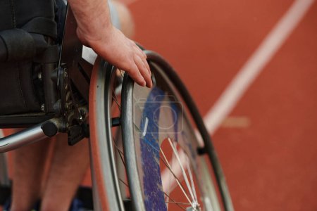 Foto de Foto de cerca de una persona con discapacidad en una silla de ruedas entrenándose incansablemente en la pista en preparación para los Juegos Paralímpicos. - Imagen libre de derechos