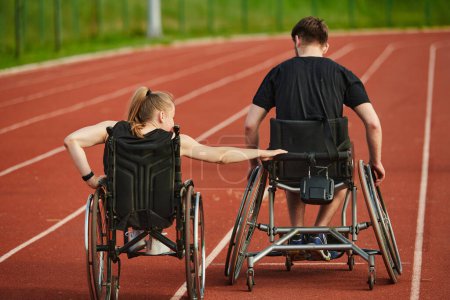 Foto de Una pareja inspiradora con discapacidad muestra su increíble determinación y fuerza mientras entrenan juntos para los Juegos Paralímpicos empujando sus sillas de ruedas en pista de maratón. - Imagen libre de derechos