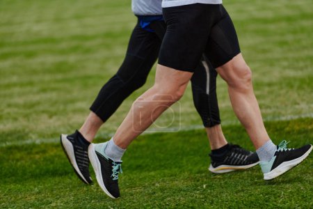 Photo for An inspiring and active elderly couple showcase their dedication to fitness as they running together on a lush green field, captured in a close-up shot of their legs in motion - Royalty Free Image