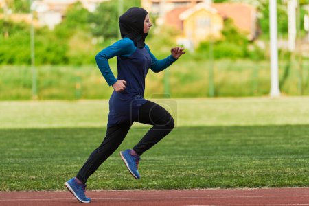 Téléchargez les photos : Une femme musulmane dans un burqa sport vêtements musulmans courir sur un parcours de marathon et se préparer pour les prochaines compétitions. - en image libre de droit