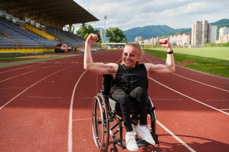 Photo for A woman with disability in a wheelchair showing dedication and strength by showing her muscles. - Royalty Free Image