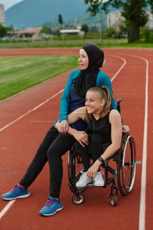 Téléchargez les photos : Une musulmane portant une burqa se reposant avec une femme handicapée après une séance d'entraînement difficile sur le parcours du marathon. - en image libre de droit