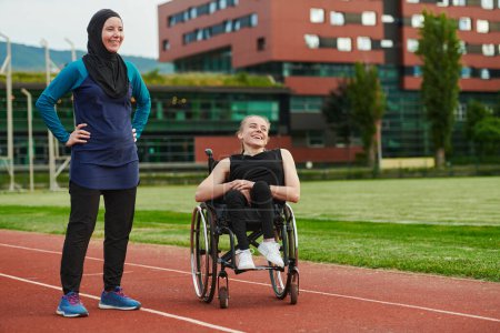 Foto de Una mujer musulmana con un burka descansando con una mujer con discapacidad después de una dura sesión de entrenamiento en el curso de maratón. - Imagen libre de derechos