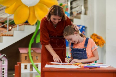 Téléchargez les photos : Enfants créatifs lors d'un cours d'art dans une garderie ou une école élémentaire dessin en classe avec une enseignante. Photo de haute qualité - en image libre de droit