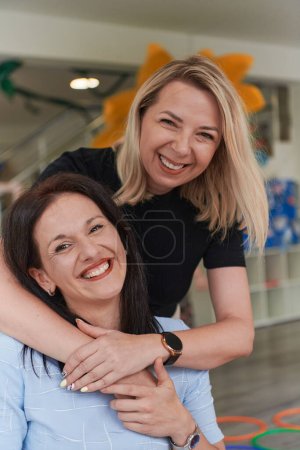 Zwei Frauen umarmen sich innig, während sie in einer Vorschule sind, und zeigen das nährende und unterstützende Umfeld für Lernen und Wachstum.