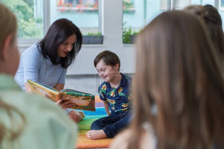 Photo for Reading time in an elementary school or kindergarten, a teacher reading a book to children in an elementary school or kindergarten. The concept of pre-school education. Selective focus. - Royalty Free Image