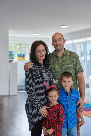 Photo for Portrait of a happy family. Photo of parents with children in a modern preschool classroom. Selective focus . - Royalty Free Image
