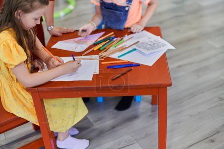 Foto de Niños creativos durante una clase de arte en una guardería o en el aula de la escuela primaria dibujando con una maestra - Imagen libre de derechos