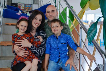 Photo for Portrait of a happy family. Photo of parents with children in a modern preschool classroom. Selective focus . High quality photo - Royalty Free Image