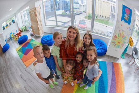 Photo for Children in a preschool institution standing in the classroom together with the teacher. High quality photo - Royalty Free Image