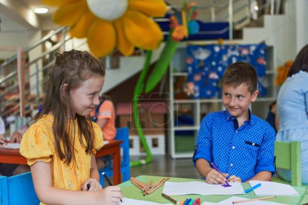 Photo for Cute girl and boy sit and draw together in preschool institution. High quality photo - Royalty Free Image